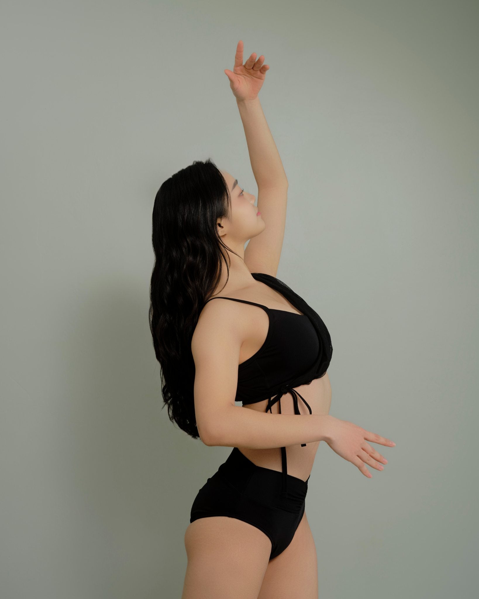 Side view of the Metamorphosis Signature Set - Black, featuring a mesh overlay top and high-waisted V-cut bottom. Available in sizes S, M, L for pole fitness.