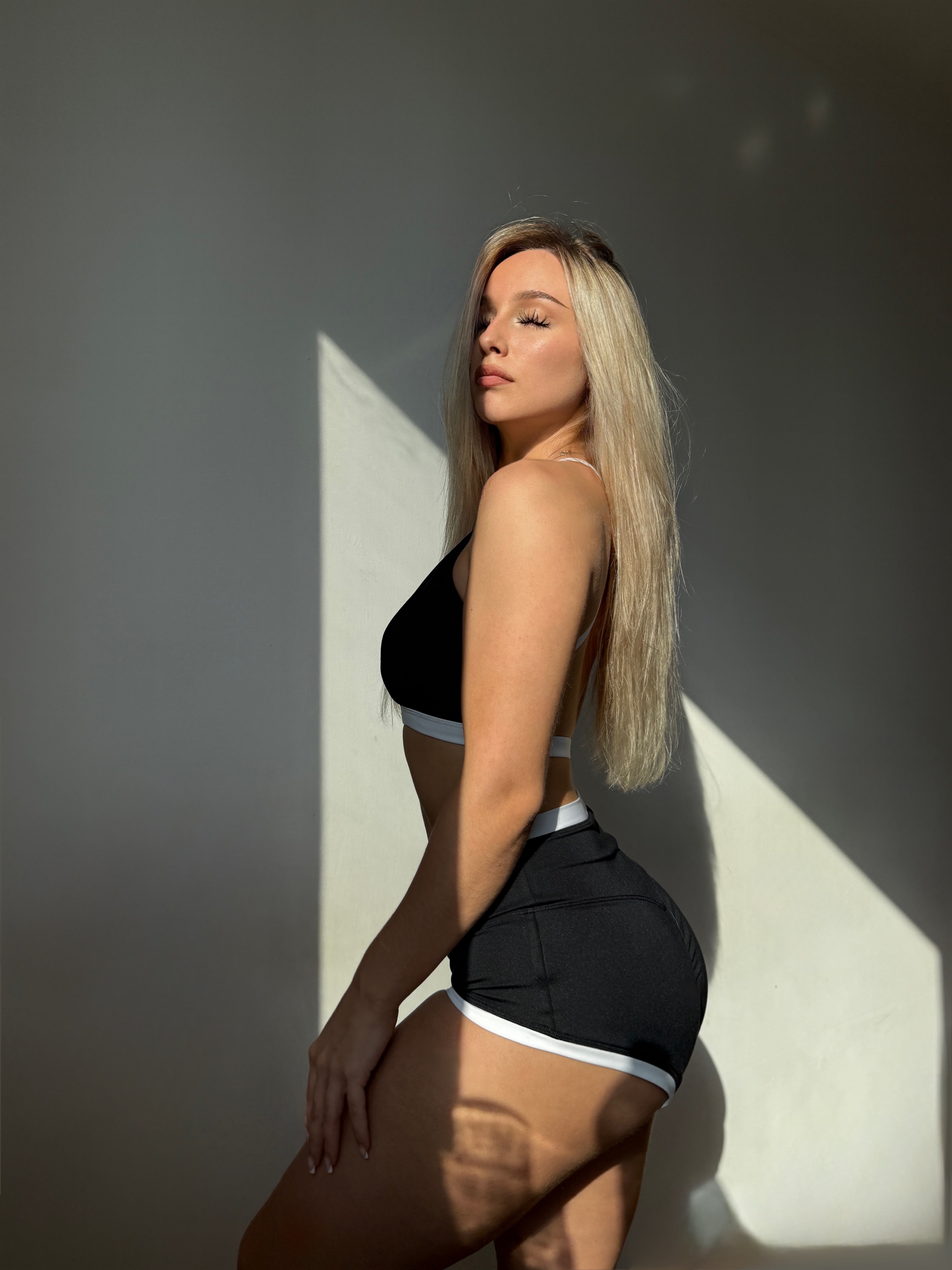 Close-up of Haru Daily Backless Top polewear in black, recycled fabric with supportive fit