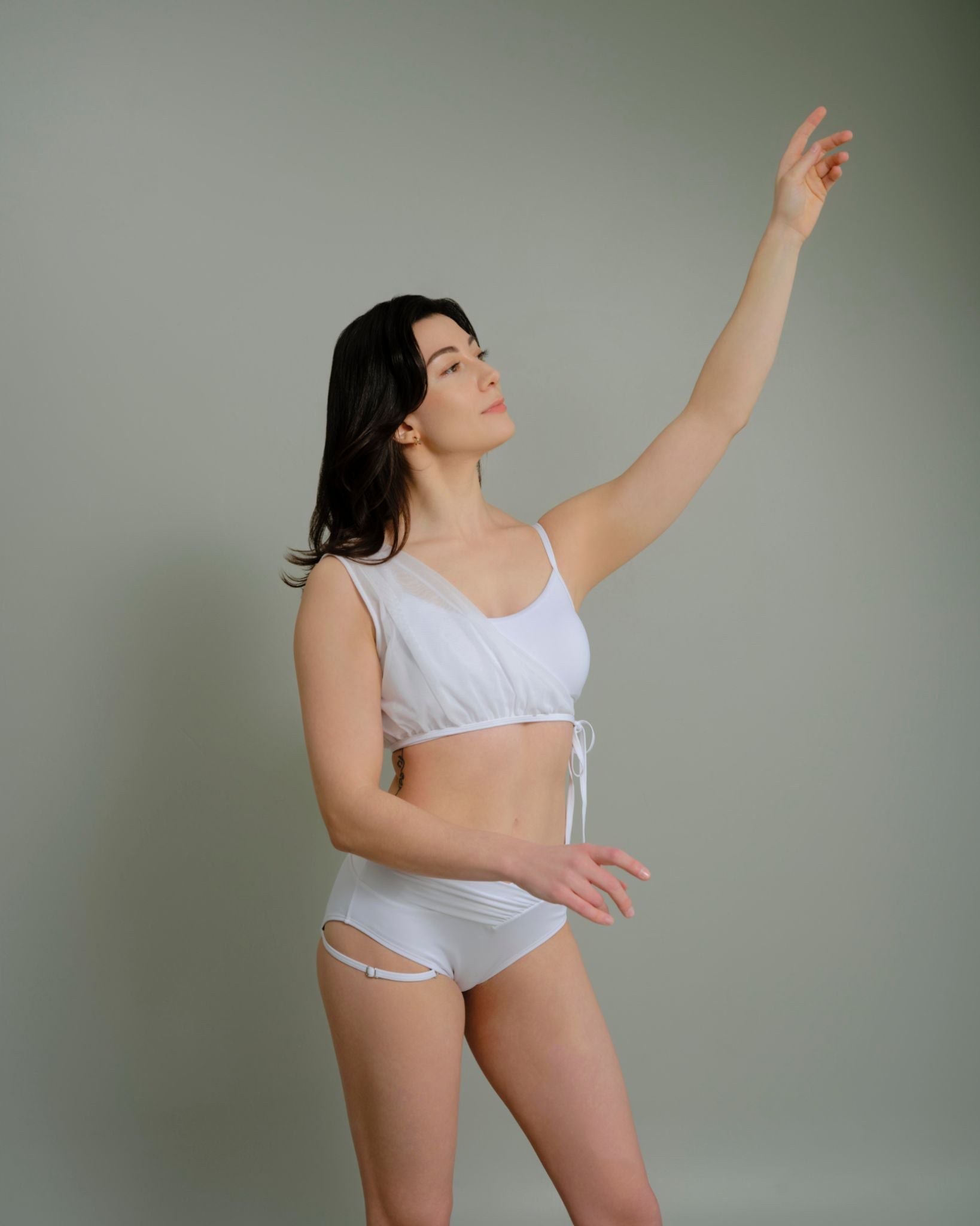 Woman posing in Metamorphosis Signature Set - White, available in sizes S, M, L. Sustainable polewear featuring a mesh overlay, adjustable straps, and elegant design.

