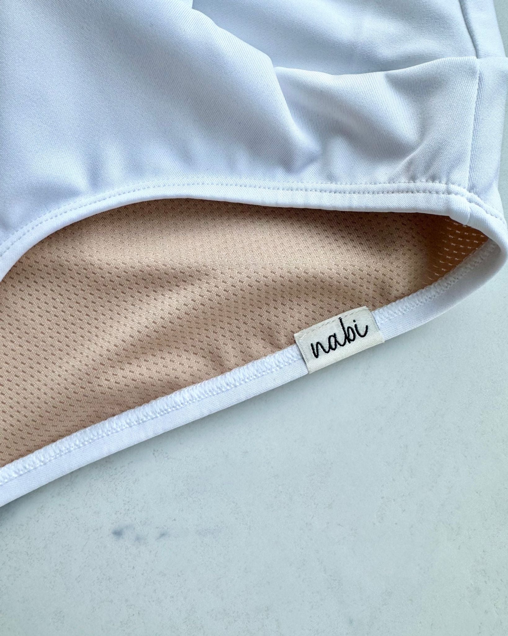 Close-up of the inner lining of Metamorphosis Signature Set - White, available in sizes S, M, L. Made from sustainable recycled materials for comfort and full coverage.